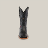 An upright black cowboy boot with a reptile-like texture and stylish square toe design is showcased against a white background. This Exotic Lizard - Black - Square Toe boot features intricate shaft stitching and a tan sole.