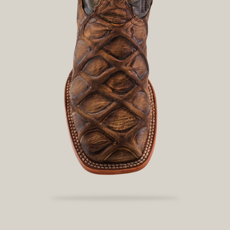 Close-up of the Big Bass Pirarucu Print Rustic Orix - Square Toe boot, made from cowhide leather with a Pirarucu print and detailed edge stitching. The white background highlights the boots distinctive textured design.