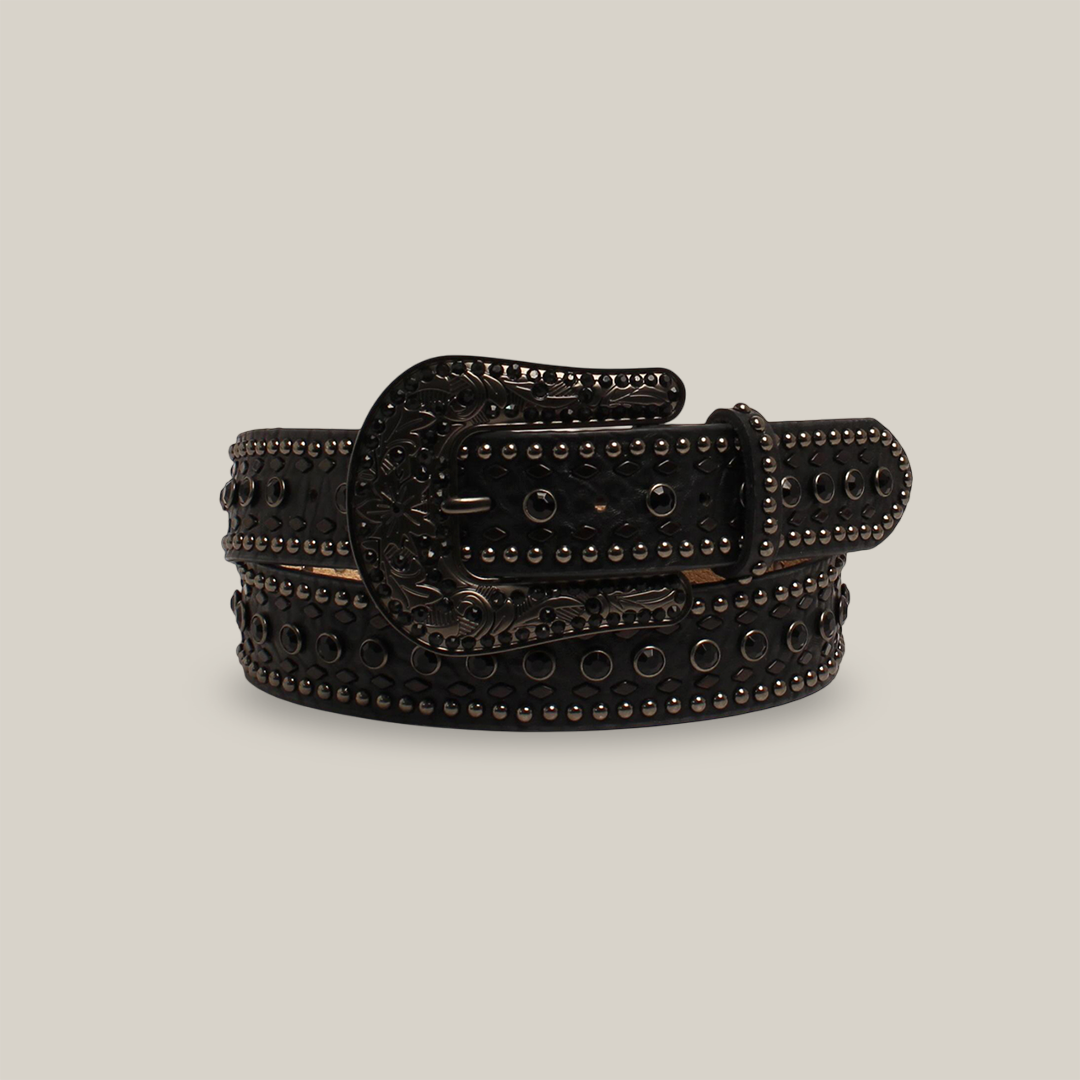 The N.1 1/2BKrhnstnNH BK belt, crafted from black leather and adorned with metallic studs and circular ornaments, exudes western elegance. It features an ornate engraved metal buckle and is displayed rolled up against a plain white background.