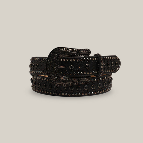 The N.1 1/2BKrhnstnNH BK belt, crafted from black leather and adorned with metallic studs and circular ornaments, exudes western elegance. It features an ornate engraved metal buckle and is displayed rolled up against a plain white background.