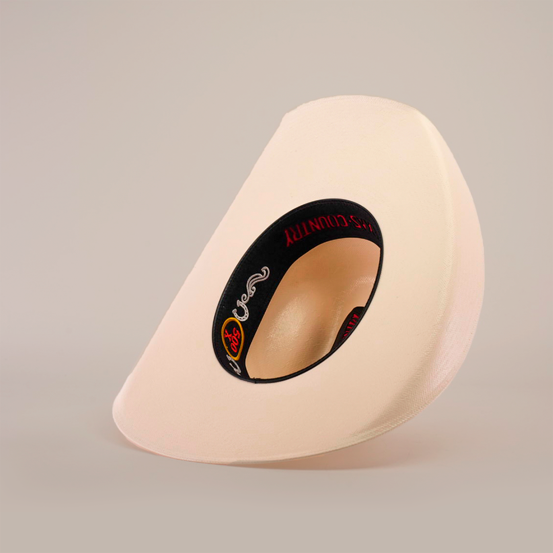 A modern cream-colored object with a unique shape and black interior, featuring a logo and red text, mirrors the playful yet refined look of the 500X Chihuahua Straw Hat, standing elegantly against a white background.