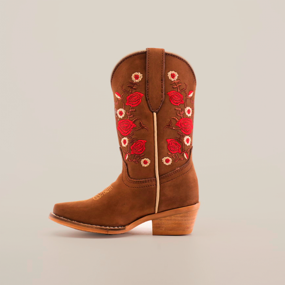 A handcrafted brown cowboy boot with a wooden heel and red and white floral embroidery on the shaft is displayed against a plain white background, similar to the Mia Copper Suede - Snip Toe boots.