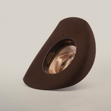 The 6X Chihuahua Brown, a premium sheep wool cowboy hat, is shown from an angle to highlight the inside band and design details. Crafted with care, this Western hat stands upright against a plain white background.