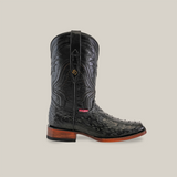 The Exotic Ostrich - Black - Rodeo Toe is a black cowboy boot with intricate stitching, a pointed toe, unique ostrich leather texture, handcrafted wooden heel, and features a small decorative emblem on light beige near the top.