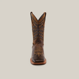 A single Azkar Tan cowboy boot with intricate stitching and a square toe is centered on a plain, off-white background. Crafted from premium cowhide, the boot features a tall shaft with decorative patterns and a slip-resistant sole for added stability.