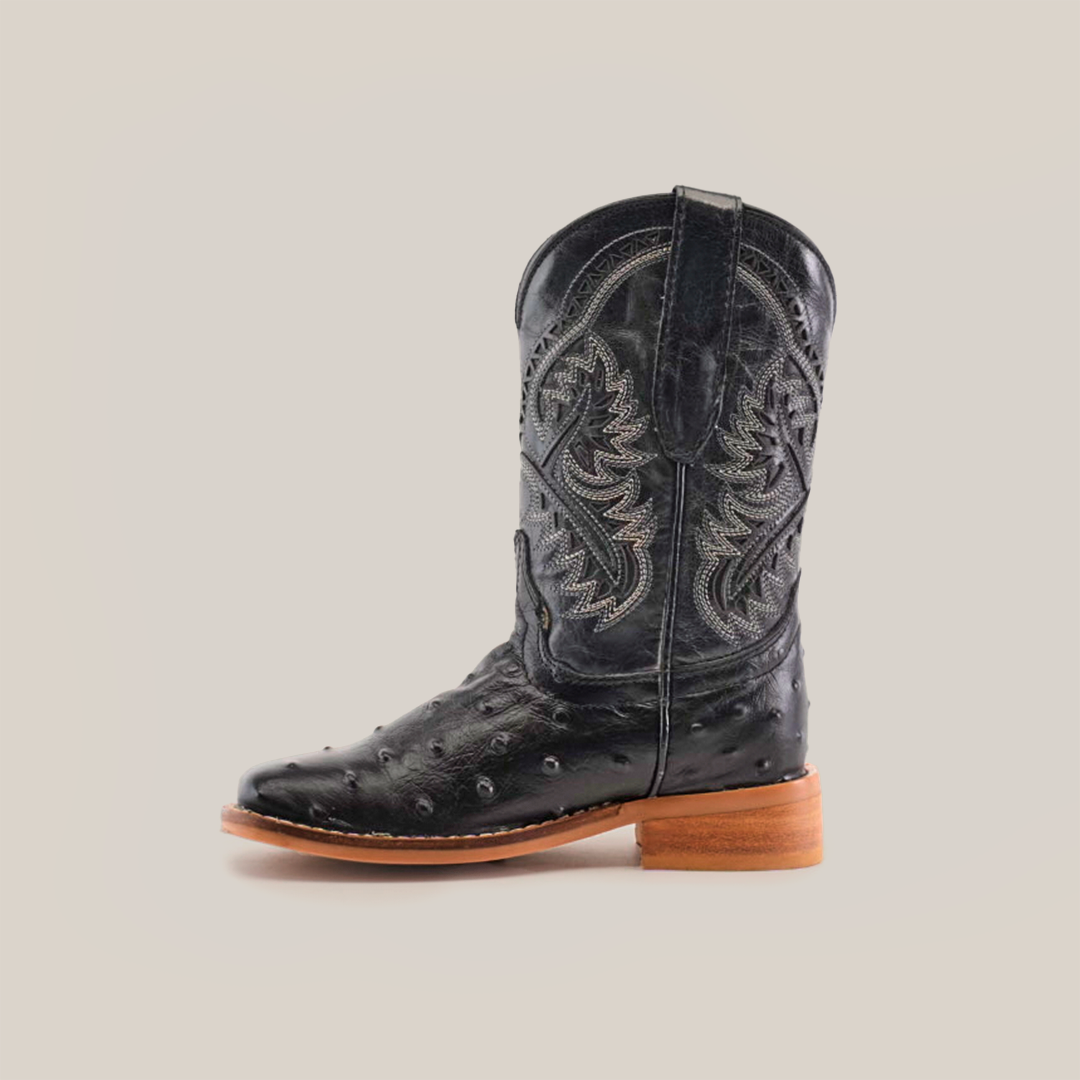 The Karoo Ostrich Print Black Square Toe cowboy boot is made from premium black cowhide leather, featuring intricate shaft embroidery and a light brown wooden heel. Its square toe boasts small decorative patterns for a textured look.