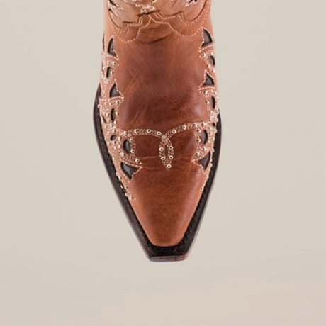 The Flipy Honey - Short Shaft - Snop Toe is a brown leather cowboy boot featuring delicate silver detailing and cutouts on the upper, showcasing traditional bootmaking artistry from a top view against a white background.