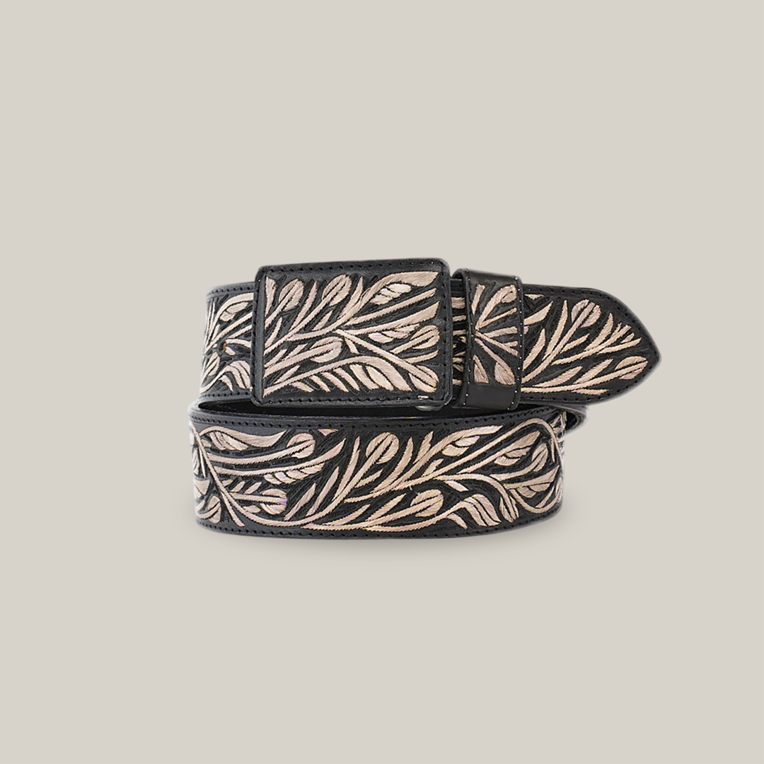 The Artisanal Handmade Silver Belt Flowers is a black belt featuring an intricate beige leaf pattern. With swirling leaves and silver thread embroidery adorning the belt and buckle, it beautifully showcases artisanal craftsmanship.