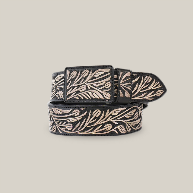 The Artisanal Handmade Silver Belt Flowers is a black belt featuring an intricate beige leaf pattern. With swirling leaves and silver thread embroidery adorning the belt and buckle, it beautifully showcases artisanal craftsmanship.