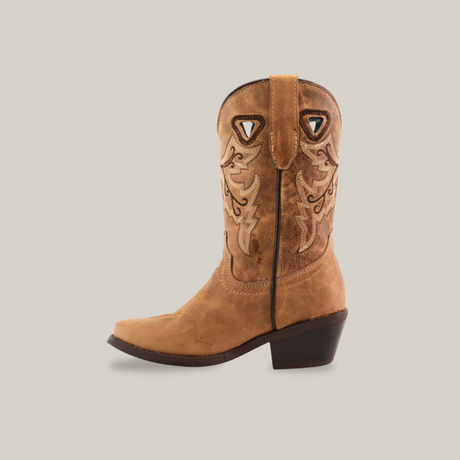 The Matcat Fawn - Snip Toe boot is tan with detailed shaft embroidery, brown stitching, and crafted from premium leather. It features a pull tab, dark brown angled heel, and cutout shapes near the top.