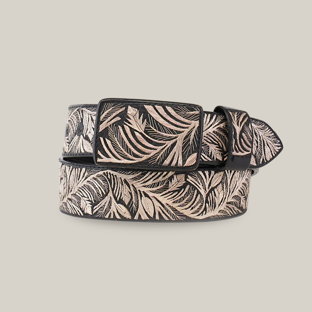 The Artisanal Handmade Silver Belt Branches Deluxe is a stylish black belt featuring intricate beige leaf patterns, subtle silver thread embroidery, and a polished buckle, exuding luxury and artisanal beauty.