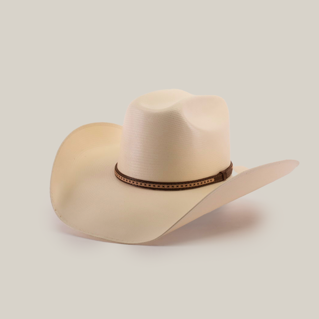 The 1000X Bull Straw Hat features a wide, curved brim and a brown decorative band, offering durability for outdoor adventures. Its light beige hue stands out against the plain white background.