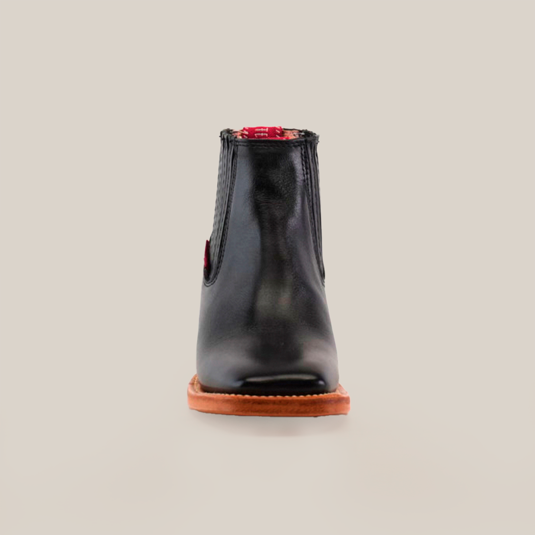 The Napa Black Square Toe boot features a genuine leather front view, a brown sole, and red accents at the top. Displayed on a simple light background, this boot exemplifies luxury craftsmanship.