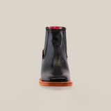 The Napa Black Square Toe boot features a genuine leather front view, a brown sole, and red accents at the top. Displayed on a simple light background, this boot exemplifies luxury craftsmanship.