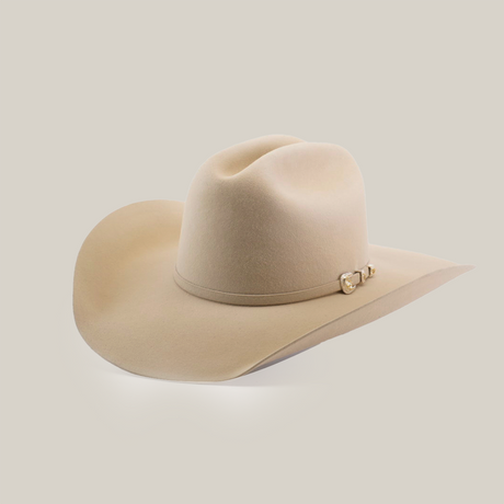 The 100X Tony Lama Belly is a beige cowboy hat crafted from premium beaver fur, exuding Western elegance with a wide brim and metal-accented decorative band, beautifully set against a plain white background to embody true Western spirit.