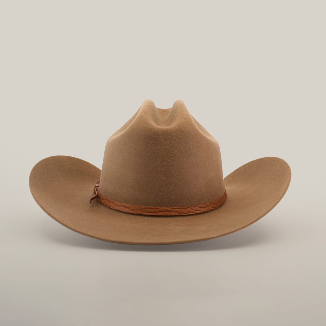 The 6X Country Fawn is a brown felt cowboy hat crafted from sheep wool, featuring a braided leather band. It rests on a plain white background, with a wide, slightly curled brim complementing its high, creased crown.