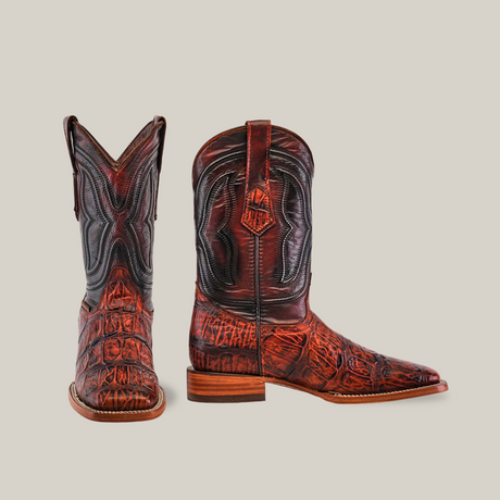 The Gator Print Cogñac Square Toe boots, crafted from premium cowhide leather, feature intricate patterns. One boot faces forward, highlighting the toe and detailed design, while the side-facing one showcases its gator print texture against a plain white background.