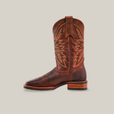 The Azkar Moka cowboy boot, crafted from supple brown cowhide leather, features intricate stitching and a decorative shaft pattern. With a square toe, wooden heel, slip-resistant sole, and an off-white background display, it combines style with stability.