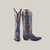 A pair of Valentina Navy - Tall Shaft - Snip Toe boots stand upright against a plain white background, showcasing intricate metallic embroidery. These artisanal cowboy boots feature slightly pointed toes, exemplifying the elegance of Western footwear.