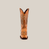 A single tan cowboy boot, the Texas Cross Glitterbomb Orix, features intricate cross and wing embroidery on premium leather. With a narrow square toe for elegance, this mid-shaft boot is centered against a plain white backdrop.