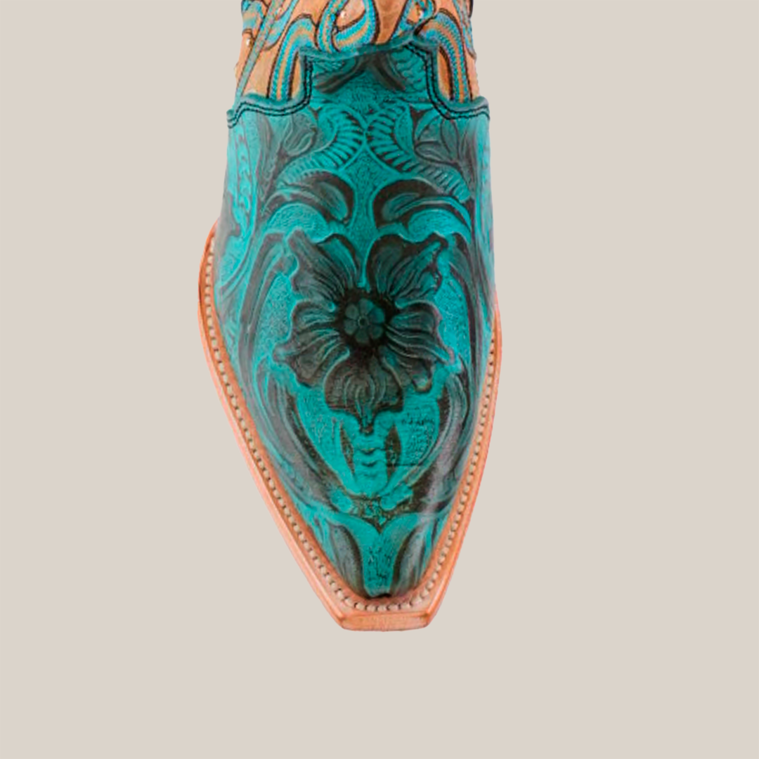 The photo features the Premier Turquoise Handtooled Flowers boot, showcasing premium leather with ornate green and black floral patterns. It has a snip toe design, intricate seam stitching, and elegant turquoise hand-tooled flowers against a plain white background.