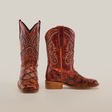 The Pirarucu Bass Print Cognac Square Toe cowboy boots feature intricate bass print patterns and a textured surface. Crafted from premium rich reddish-brown leather with a square toe and wooden heel, they stand stylishly against a plain white background.