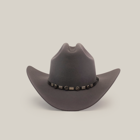 The 100X Sinaloa Oxford is a wide-brimmed, dark gray cowboy hat made from sheeps wool with a notable crown crease. It has a decorative band adorned with round and rectangular metallic accents, capturing its Western essence, all set against a plain white background.