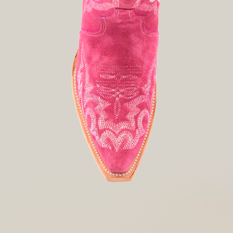 Close-up of the Amara Pink Suede Tall Shaft boot, highlighting its Western style. The snip toe displays intricate stitching, paired with a light brown sole. The upper part is partially obscured against a white background.