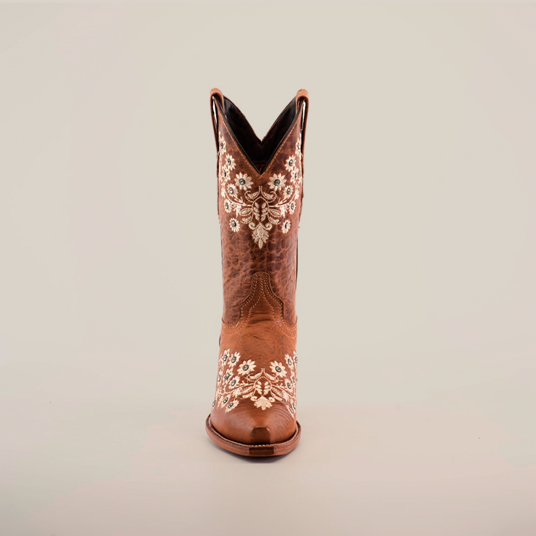 Against a white backdrop sits a single brown cowboy boot, adorned with white floral embroidery and crystal embellishments. This Western-style boot, echoing the Abril Crystals - Mid Shaft - Snip Toe design, features intricate stitching and a low heel.