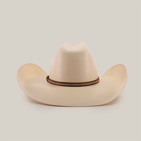 The 1000X Bull Straw Hat features a cream color, wide brim, and brown decorative band around the base of the crown. Its perfect for outdoor adventures, showcasing durability in every stitch against a plain white background.