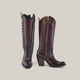 A pair of Francia Rings Tall Shaft Chocolate boots crafted from premium leather, with block heels and side zippers. The left boot is front-facing, while the right showcases a decorative chain along the back, embodying sleek elegance.