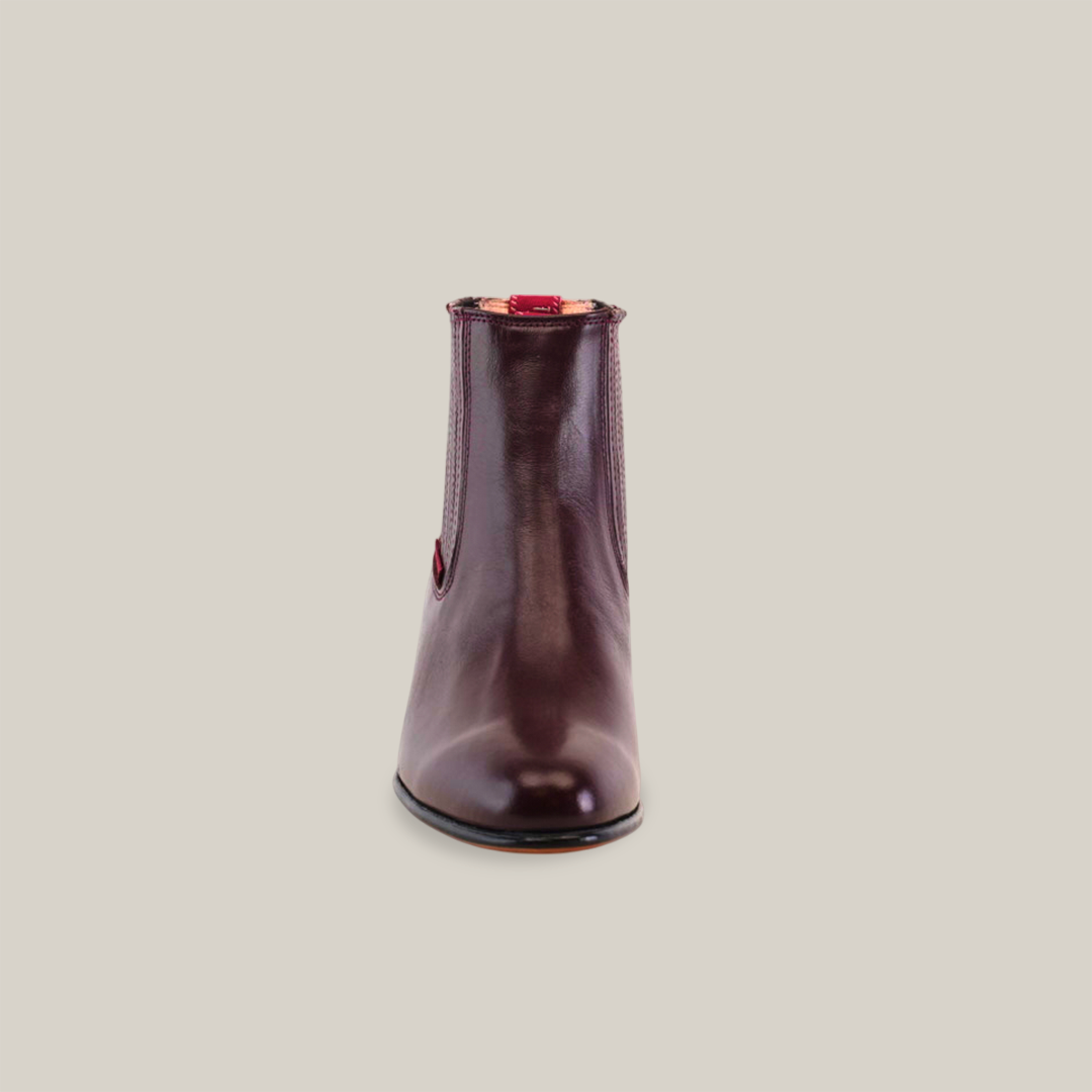 Front view of a Napa Wine - Round Toe burgundy leather ankle boot on white background. The boot showcases artesanía excepcional, featuring a smooth texture and glossy finish, embodying calidad excepcional with its bota de punta redonda design.