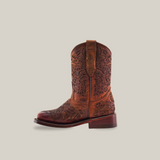 The Yennis Brick Square Toe boot showcases a brown, premium leather design with intricate floral embroidery on a plain white background. It features a short heel and a pull tab at the top, seamlessly combining style with quality craftsmanship.