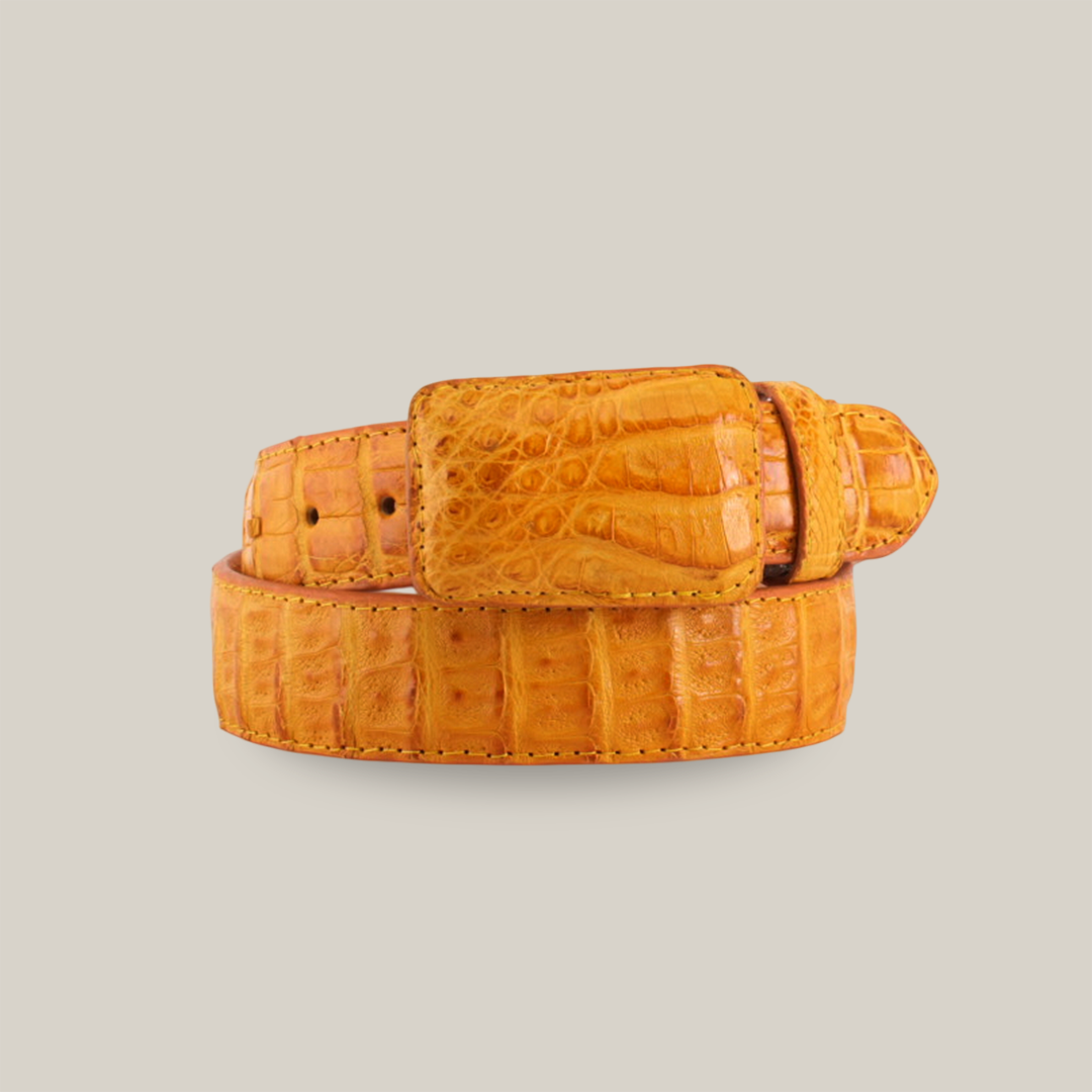 The Exotic Full Quilt Caiman - Bettercup Belt, in a coiled display against a white background, boasts a textured crocodile skin pattern in bright orange. It includes a matching orange buckle and is crafted from genuine leather.