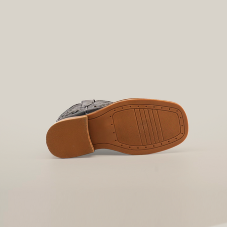 Bottom view of a single Python Print Black Square Toe shoe on white background. The light brown cowhide leather sole has textured rectangular and linear grooves for grip, with a slightly raised heel.