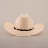 The 5000x Sinaloa Straw Hat is a beige cowboy hat featuring a black band with metal accents. Its high crown and wide brim highlight exceptional craftsmanship, set against a plain white background.