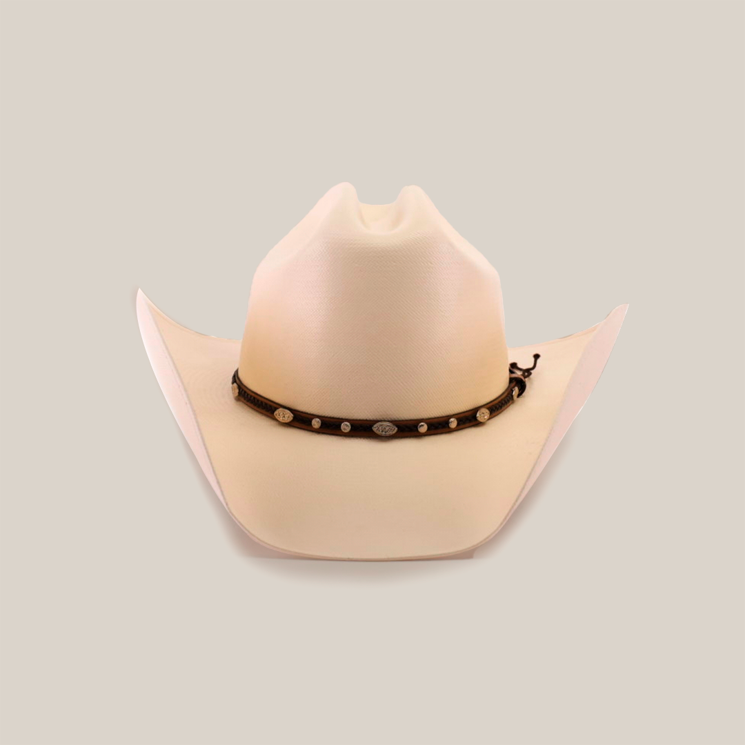 The 1000X Country Straw Hat, a beige masterpiece, features a wide brim and a decorative black band adorned with small silver conchos around the base of the crown, set against a white background. Crafted from high-quality materials, this cowboy hat stands out for its impeccable design and style.