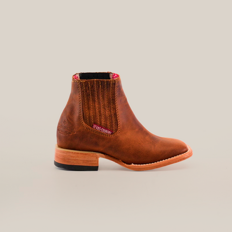 The Avejentado Honey Square Toe ankle boots feature a brown leather design, side elastic panels, intricate stitching, a textured sole, and slight heel. They are handcrafted and include a red and white pull tab at the back.