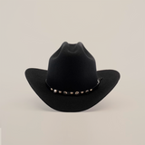 The X 2 Carnales Black is a felt cowboy hat, featuring a wide brim and decorative band with metal accents, ideal for western headwear, showcased against a white background.