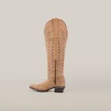 A Madona Sand Suede Tall Shaft cowboy boot with intricate embroidery and a side zipper stands against a white background. This handcrafted snip-toe boot exudes elegance with its slightly pointed toe and chunky heel.