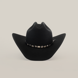 The 6X Country Black felt cowboy hat showcases a wide brim and a decorative leather band with circular and rectangular silver elements around the crown, set against a plain white background.