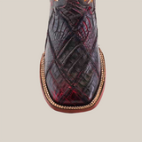 The Exotic American Alligator Patchwork Black Cherry Square Toe is a cowboy boot featuring rich brown and black cherry crocodile texture, visible from above. It has a square toe, detailed edge stitching like patchwork, and a sole with light decorative trim on plain white.