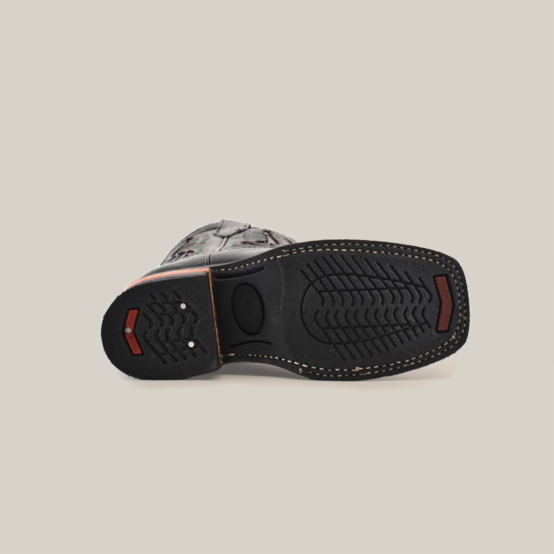 A cowboy boot with a black textured rubber sole featuring red accents, crafted from premium cowhide leather. Detailed stitching enhances its rugged look. Perfect for a stylish statement, this design is the Barcelona Black Lustre Rodeo Toe.