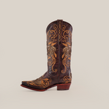 The Rosal Chocolate - Mid Shaft - Snip Toe boot is handcrafted from premium leather, adorned with intricate golden floral embroidery and swirling patterns on the shaft and toe, all displayed on a plain white background, offering elegant and authentic Western footwear style.