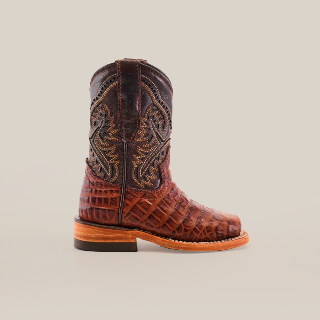 The Caiman Belly Print Chocolate Square Toe boot displays intricate embroidery on its upper and a Caiman Belly Print on the lower. Handcrafted from premium leather, it features a wooden sole and square toe, all set against a plain white background.