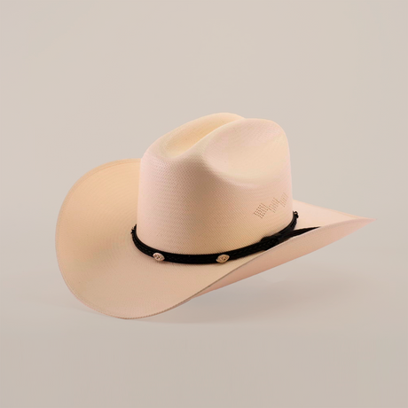 The 500X Sinaloa Straw Hat is a cream-hued cowboy hat with a slightly curved brim and indented crown, set against a plain white backdrop. It boasts timeless style and top-notch quality, featuring a black band with decorative emblems around the crowns base.