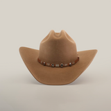 The 6X Country Fawn is a light brown felt cowboy hat featuring a wide brim and a leather band with silver conchos, set against a plain white background.