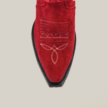 Close-up of the Amara Red Suede - Tall Shaft - Snip Toe boot, showing intricate white floral and geometric stitching on red suede. This womens boot features a pointed toe with black edges, elegantly showcased against a plain white background.