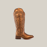 Set against a plain white background, this Eden Copper Tall Shaft boot highlights luxury craftsmanship with intricate side stitching. It pairs a low heel with a narrow aquare toe, blending style and sophistication.