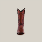 The Exotic Caiman Belly Tail boot in brandy features a square toe and rich leather texture. Displayed against a white background, the front view highlights its intricate stitching and craftsmanship.